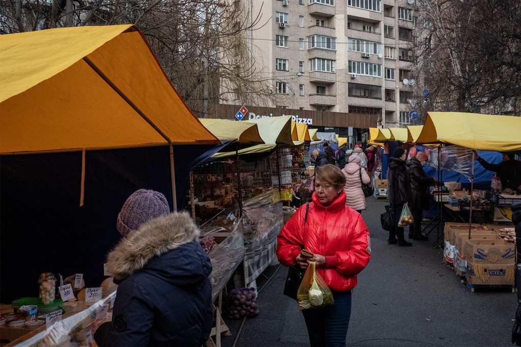 La gente compra en un mercado al aire libre en Kiev en medio de las tensiones entre Ucrania y Rusia el 11 de febrero de 2023.