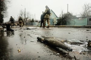 Soldados ucranianos inspeccionan los restos de una columna blindada rusa destruida en una carretera en Bucha, un suburbio al norte de la capital, Kiev.