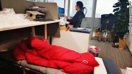 Los comerciantes duermen junto a sus escritorios mientras el centro financiero de China está cerrado