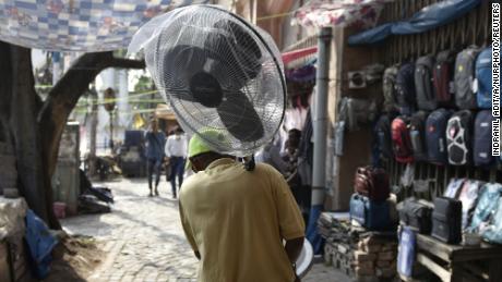 Un hombre sostiene un ventilador durante una ola de calor en Kolkata, India.