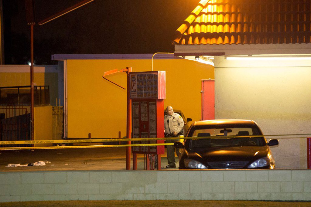 Un oficial del Departamento del Sheriff del condado de Los Ángeles revisa la escena de un accidente en un estacionamiento en Compton, California, el jueves 29 de enero de 2015. 