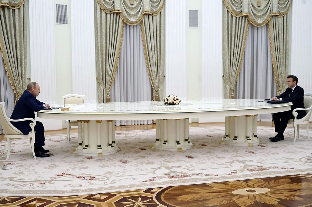 Putin y Marcon sentados uno frente al otro en una mesa en Moscú