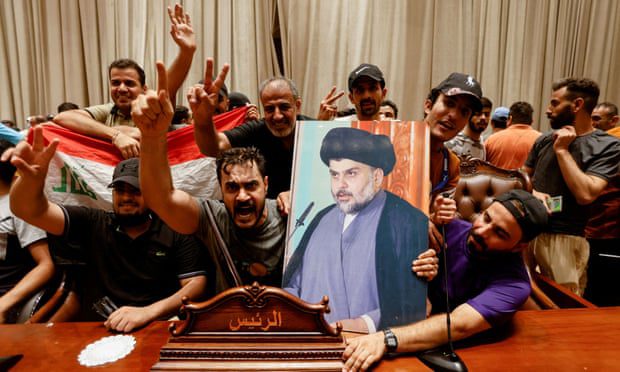 Los partidarios llevan una foto del clérigo chiíta iraquí Muqtada al-Sadr dentro del edificio del parlamento en Bagdad.