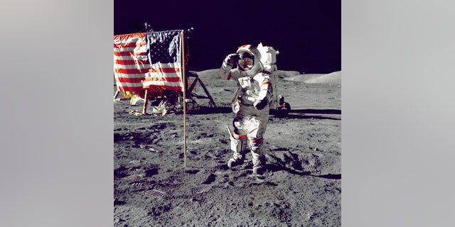 El astronauta Eugene A.  Cernan, el comandante del Apolo 17, saluda a la bandera estadounidense en la superficie lunar durante la actividad extravehicular (EVA) en la reciente misión de alunizaje de la NASA.  unidad lunar "Desafiador" En el fondo izquierdo está la bandera y los Lunar Rovers (LRV) también están en el fondo.  Cernan fue el último hombre en caminar sobre la luna después de completar el programa Apolo. 