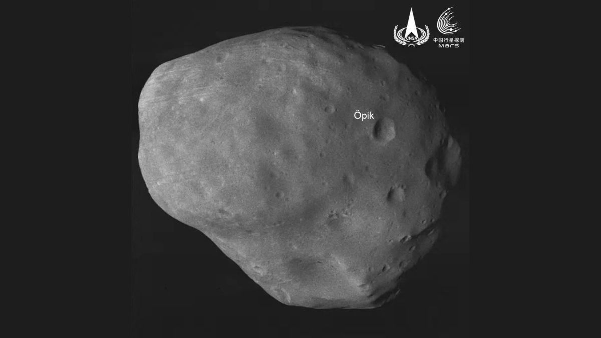 A photo of a potato-shaped moon with one large crater marked