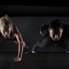 Esto muestra a un hombre y una mujer haciendo flexiones.