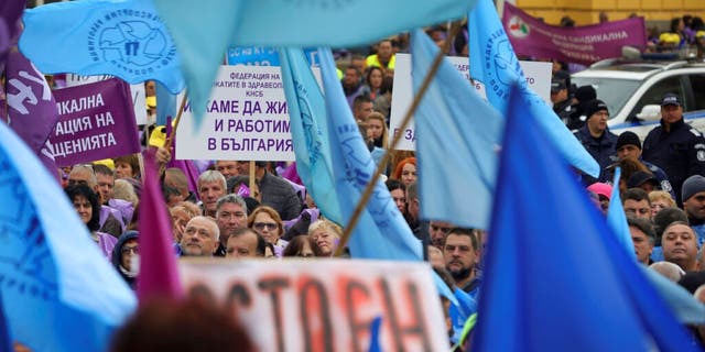 Los manifestantes sostienen pancartas y cantan por un salario decente en la víspera del invierno frente al edificio del Parlamento en Sofía, Bulgaria, el viernes 11 de noviembre de 2022.
