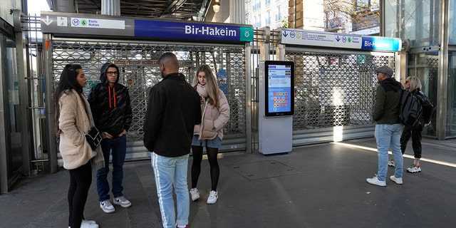 La gente se para frente a una estación de metro cerrada el jueves 10 de noviembre de 2022 en París.  Los trabajadores en huelga que exigen salarios más altos cerraron la mitad de las líneas de metro en la capital francesa el jueves.
