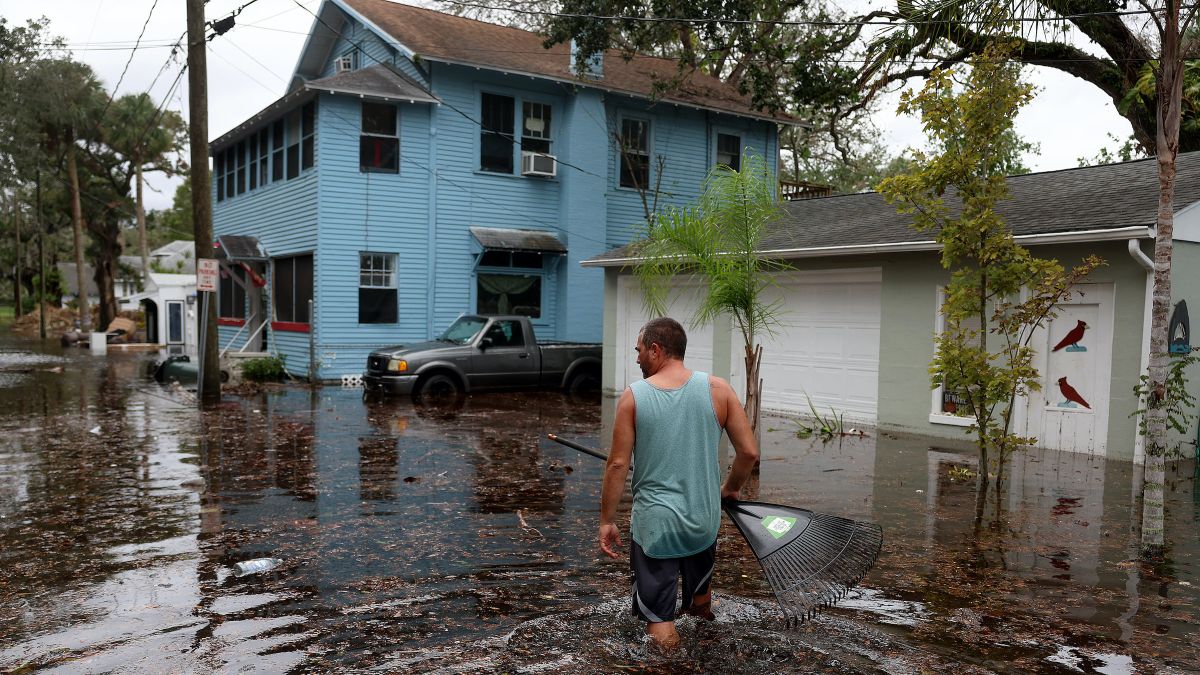 Jason Elam wades through flood waters around his home after Hurricane Nicole blew ashore on Nov. 10, 2023 in Daytona Beach, Florida.