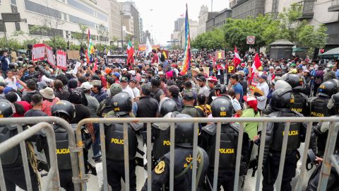 Oficiales de policía hacen guardia mientras la gente se reúne frente al Congreso de Perú después de que el presidente Pedro Castillo dijera que disolvería la asamblea el 7 de diciembre.