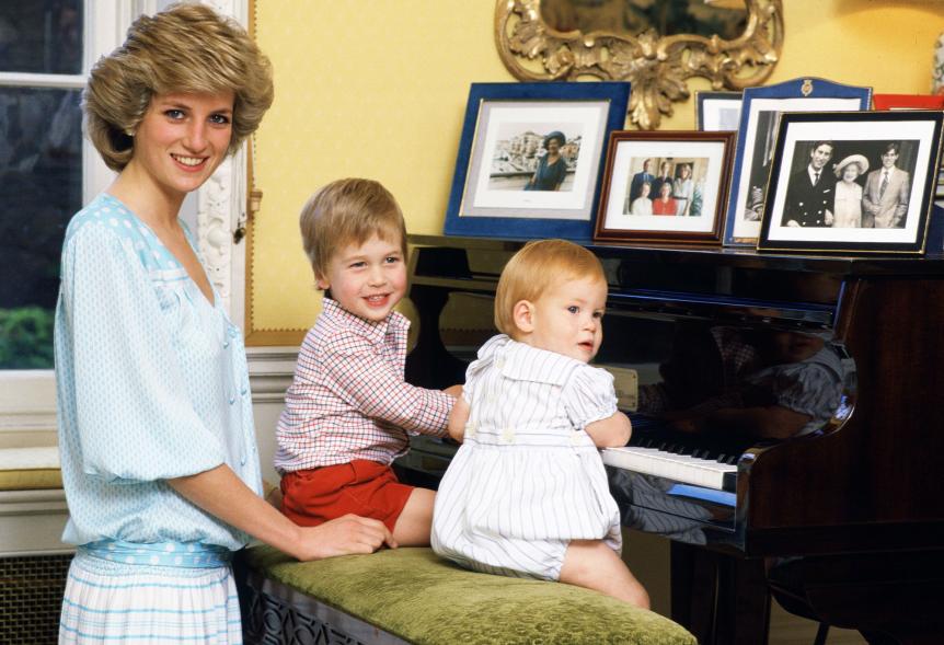 La princesa Diana sonríe mientras el príncipe Harry y el príncipe William intentan tocar el piano