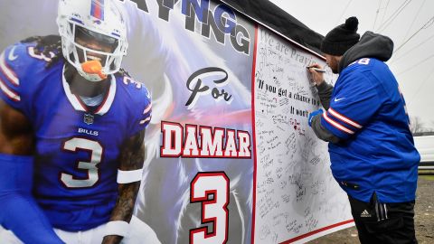 Los fanáticos firman un cartel con mensajes de apoyo para la seguridad de los Buffalo Bills, Damar Hamlin, afuera del Highmark Stadium el domingo.
