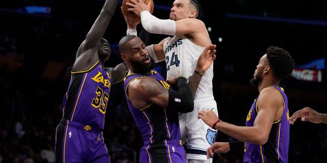 El alero de los Grizzlies de Memphis, Dillon Brooks (24), comete una falta contra el alero de los Lakers de Los Ángeles, LeBron James (6), durante la primera mitad de un partido de baloncesto de la NBA en Los Ángeles, el viernes 20 de enero de 2023. 