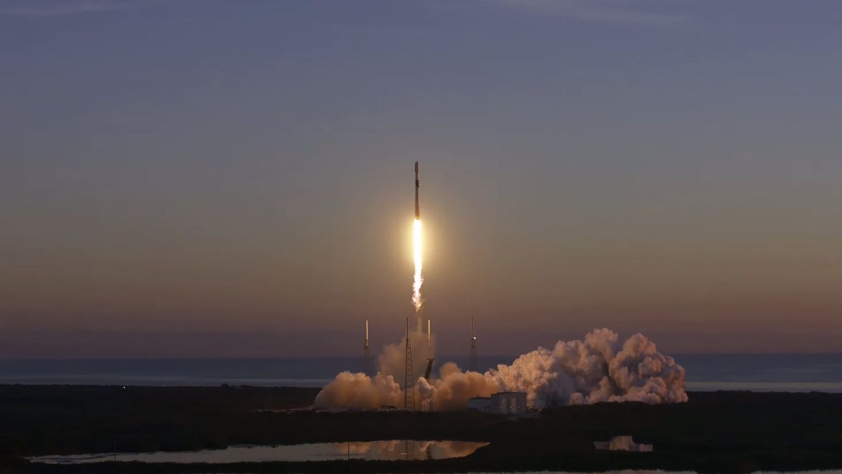 spacex rocket lifting off into dawn sky with steam billowing underneath
