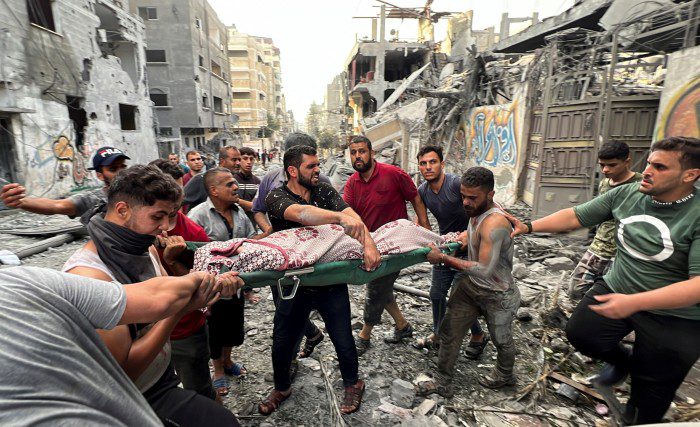Palestinos cargan cadáveres después de los ataques aéreos israelíes en la ciudad de Gaza