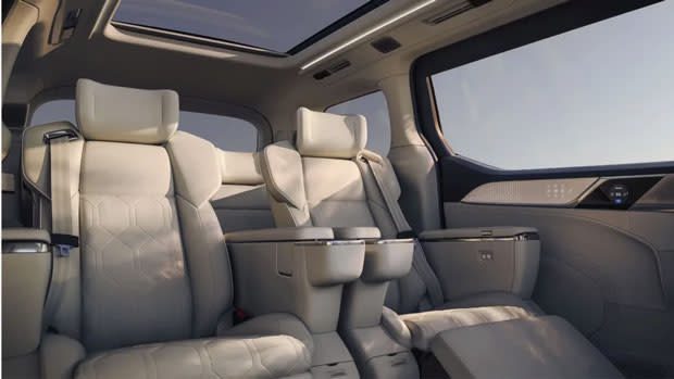 Foto del interior de un Volvo EM90 con un par de lujosas sillas reclinables blancas.