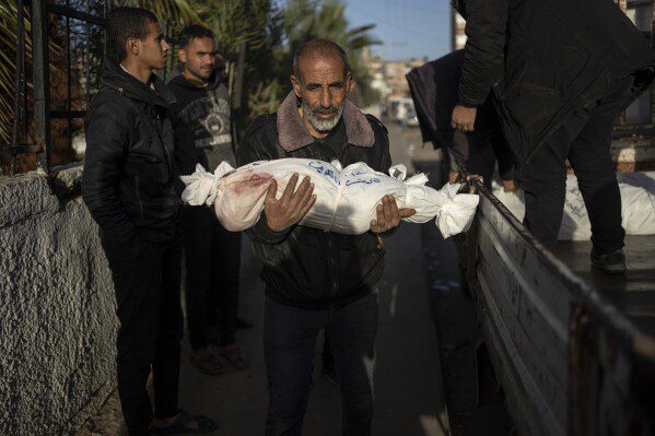 Un palestino lleva el cuerpo de su nieto, que fue martirizado en el bombardeo israelí de la Franja de Gaza, en el Hospital Rafah, al sur de Gaza, el viernes 22 de diciembre de 2023. (Foto AP/Fatima Shbair)