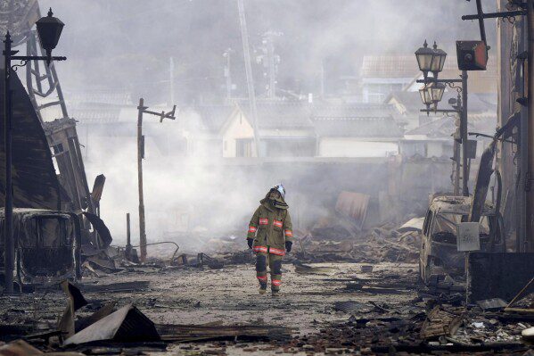 Un bombero camina entre los escombros y los escombros de un mercado incendiado tras el terremoto que sacudió Wajima, prefectura de Ishikawa, Japón, el martes 2 de enero de 2024. (Kyodo News vía AP)